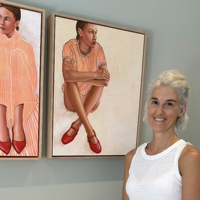 Artist with framed figuartive paintings with red shoes