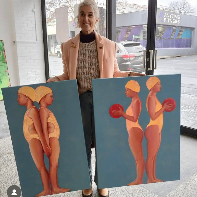 Leah Mariani holding paintings swimmers