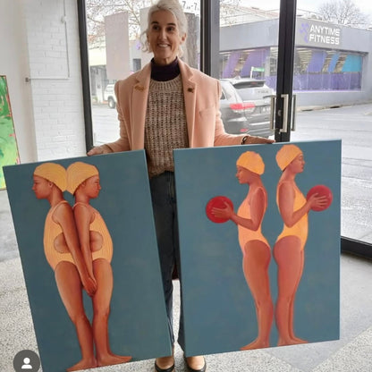 Leah Mariani holding paintings swimmers